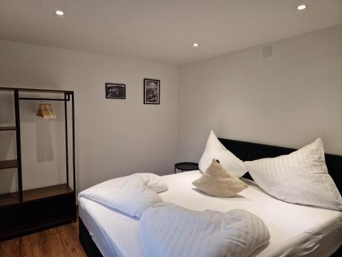 a bedroom with a bed with white sheets and pillows at Apartment Ramazotti in Bad Hofgastein