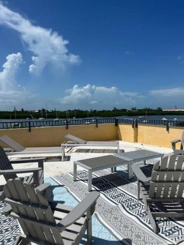 a group of chairs and tables on a patio at Boot Key Harbor Penthouse in Marathon