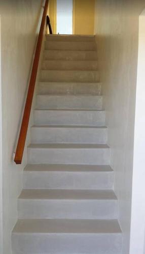 a stairway with white stairs with a person walking down it at Boot Key Harbor Penthouse in Marathon
