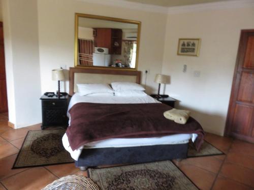 een slaapkamer met een groot bed en een grote spiegel bij Harties Lodge - Meerhof Bay View 6 in Hartbeespoort