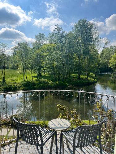 a table and chairs on a balcony overlooking a river at Hotel Il Corazziere in Merone