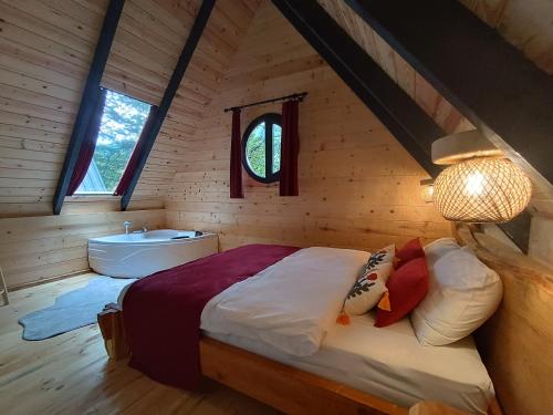 sypialnia z łóżkiem i wanną w kabinie w obiekcie SAMUR DAĞ EVLERİ w mieście Rize