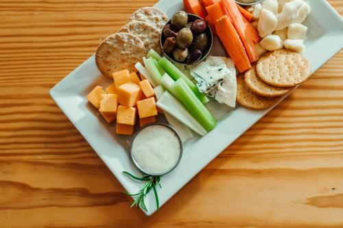 a plate of food with vegetables and crackers and dips at Hotel Skyler Syracuse, Tapestry Collection by Hilton in Syracuse