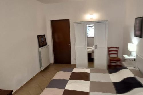a room with a checkered floor and a room with a chair at Alle Porte del Chianti in Castiglioni