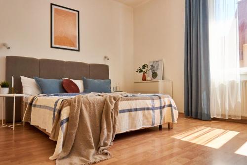 a bedroom with a large bed with blue pillows at Wonderful Panoramic View Apartment in Mukacheve
