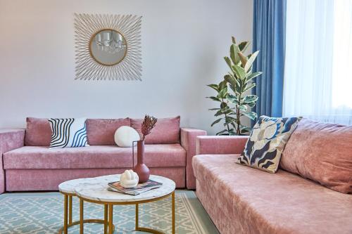 a living room with a pink couch and a table at Wonderful Panoramic View Apartment in Mukacheve