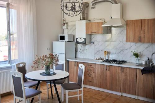 a kitchen with a table and chairs and a refrigerator at Wonderful Panoramic View Apartment in Mukacheve