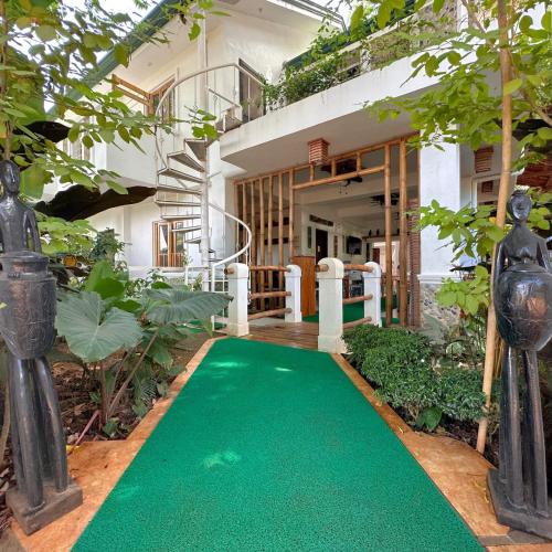 un tapis vert devant une maison dans l'établissement Earl De Princesa Hotel, à Puerto Princesa
