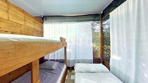 卡門阿皮卡拉的住宿－Eco Hotel Guarumal，一间卧室设有两张双层床和一扇窗户。