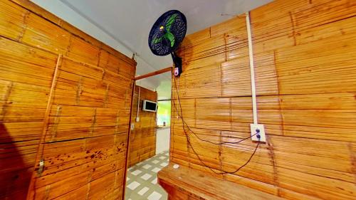 Habitación con pared de madera y ventilador. en Eco Hotel Guarumal, en Carmen de Apicalá