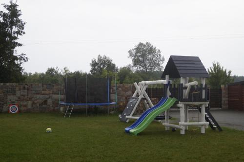 a playground with a slide in a yard at Domki Letniskowe Kraina Jodu in Bobolin