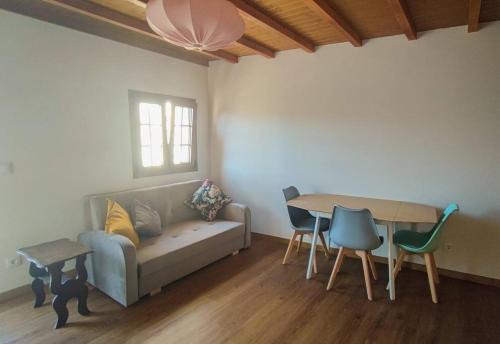 a living room with a couch and a table and chairs at Casa da Praça in Freixo de Numão