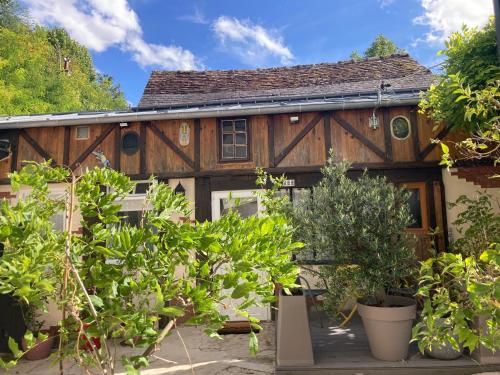 une maison en bois avec des plantes devant elle dans l'établissement Gîte cosy entre Tours et Amboise, à Vernou-sur-Brenne