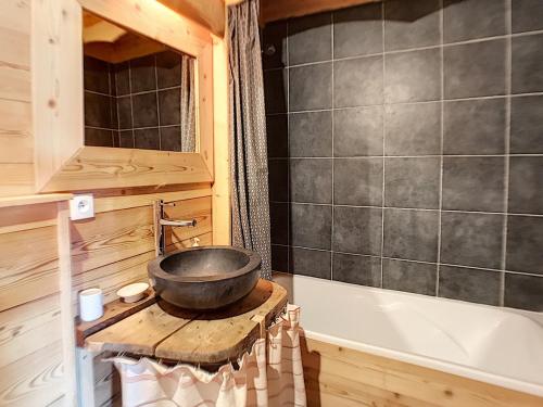 a bathroom with a bowl on a table next to a tub at Chalet en bois, 4 chambres, WIFI, skis, parking proche, 8 pers - FR-1-344-791 in Saint-Marcel