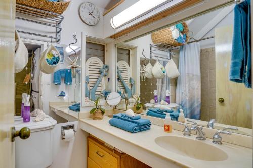 a bathroom with a sink and a large mirror at Oceanfront Maunaloa Condo, Steps to Pool and Beach! in Maunaloa