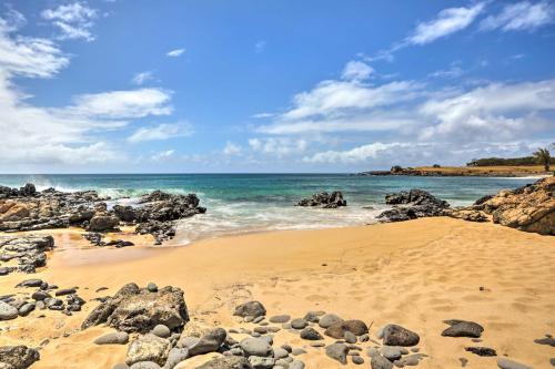 a sandy beach with rocks and the ocean at Oceanfront Maunaloa Condo, Steps to Pool and Beach! in Maunaloa