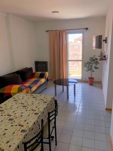 una sala de estar con un sofá y una mesa en Dpto Bon Lee, en Puerto Madryn