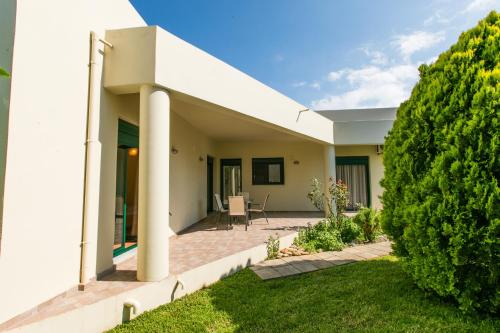 a white house with a lawn in front of it at Villa Athina in Asprouliánoi