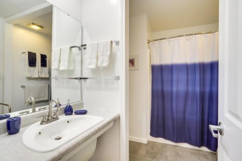 a bathroom with a sink and a blue shower curtain at Modern and Spacious Home - 6 Mi to Dtwn South Bend in Granger