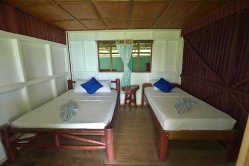 ドラケにあるCabinas vista isla del caño corcovadoのベッド2台、テーブル、窓が備わる客室です。