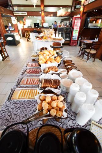 a long table with many different types of food on it at Pousada Acqua Azul in Bertioga