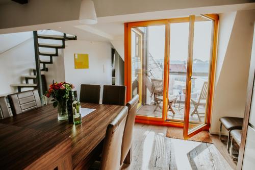 ein Esszimmer mit einem Holztisch und einem Balkon in der Unterkunft traumhaftes Apartment am Dom mit großer Dachterrasse in Zwickau