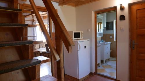 a room with a kitchen and a staircase with a refrigerator at Cesta z mesta na Huty in Huty