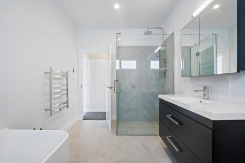 un bagno con doccia, lavandino e specchio di Stylish Serenity - Martinborough Holiday Home a Martinborough