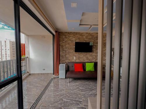 a living room with a couch and a television at Bello apartaestudio Alto Living in Cali
