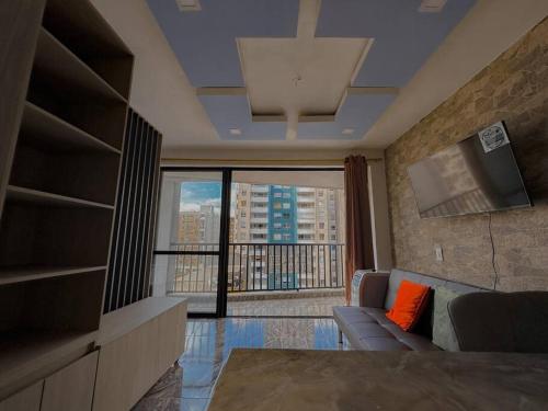 a living room with a couch and a large window at Bello apartaestudio Alto Living in Cali