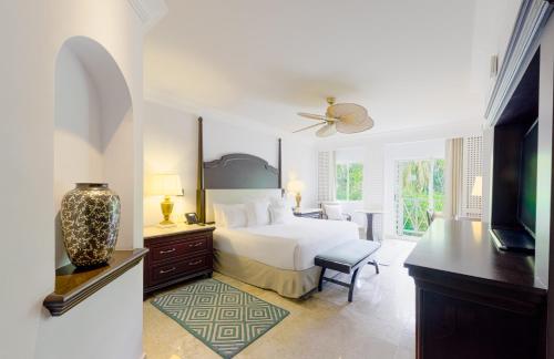 um quarto branco com uma cama e uma televisão em Royal Hideaway Playacar All-Inclusive Adults Only Resort em Playa del Carmen