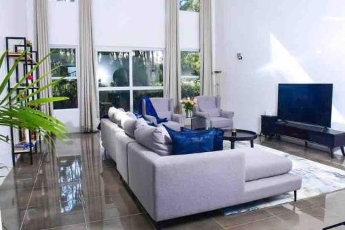 un soggiorno con divano bianco e TV di The White House a Eldoret