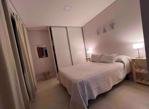 um pequeno quarto com uma cama e uma mesa em Depto acogedor, moderno y espacioso em Rosário
