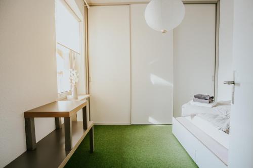 a room with a green floor and a table at traumhaftes Apartment am Dom mit großer Dachterrasse in Zwickau