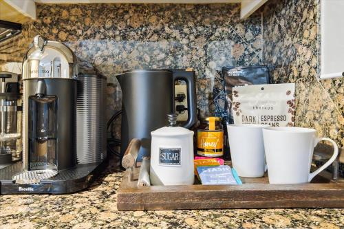 a counter with a coffee maker on a wooden tray at Biltmore Bliss Desert Retreat! in Phoenix