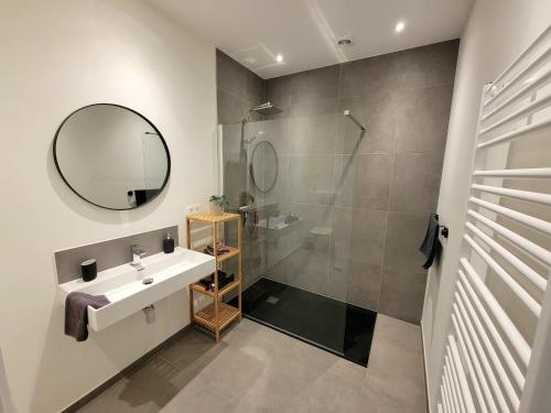a bathroom with a shower and a sink and a mirror at Family apartment on the ground floor with terrace - Panne A Côte in De Panne