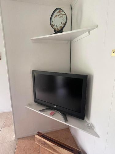a tv sitting on a shelf in a room at The Sundown Lodges Rarotonga in Arorangi
