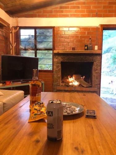 sala de estar con mesa y chimenea en MINAS BAJO, en Quito