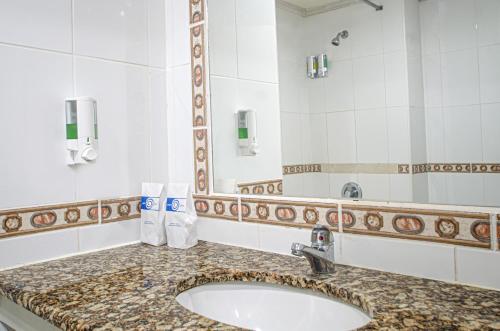 a bathroom with a sink and a mirror at Sunbay Hotel in Christ Church