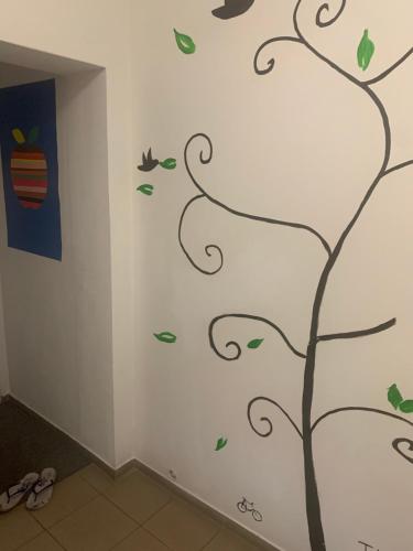 a wall with a tree and birds stenciled on it at 3 Apartments in 1 location in Prague