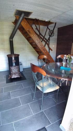 a dining room with a table and a wood stove at Domaine des Terres du Milieu / Gîte de cul de sac in Châteldon