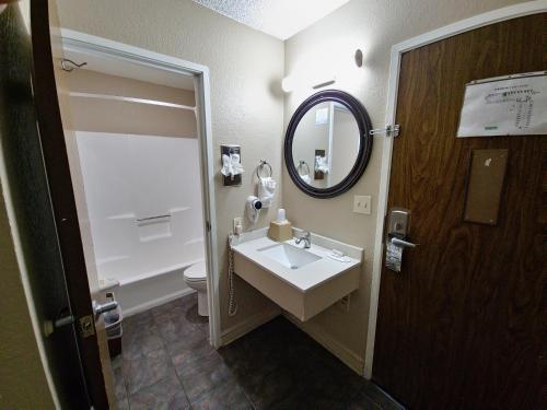 a bathroom with a sink and a mirror and a toilet at Super 8 by Wyndham Goodyear/Phoenix Area in Goodyear
