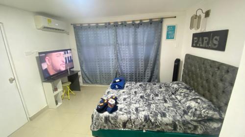 um quarto com uma cama e uma televisão de ecrã plano em Casa Family 5 em Cartagena das Índias