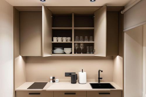 a kitchen with white cabinets and a sink at Birzes dzīvoklis (Birzes condo) in Cēsis