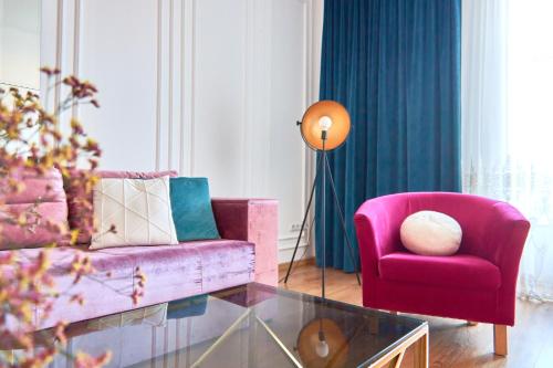 uma sala de estar com um sofá rosa e uma cadeira em Elegant Lux Apartment in central square em Mukacheve