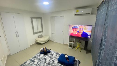 uma sala de estar com uma televisão de ecrã plano e uma cama em Casa Family 5 em Cartagena das Índias