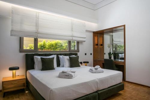 1 dormitorio con 1 cama con 2 toallas en Rodi Luxury Apartment, en Rodas