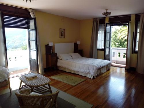 1 dormitorio con 1 cama, mesa y sillas en Villa Alicia LA PERLA INDIANA en Salas