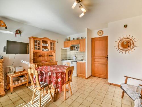 une cuisine avec une table et des chaises dans une pièce dans l'établissement Studio calme avec cabine, terrasse et parking – Centre des Gets à 2 pas, 4 pers. - FR-1-685-56, aux Gets