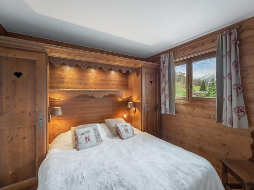 1 dormitorio con 1 cama con pared de madera en Appartement Méribel, 3 pièces, 4 personnes - FR-1-566-57, en Les Allues